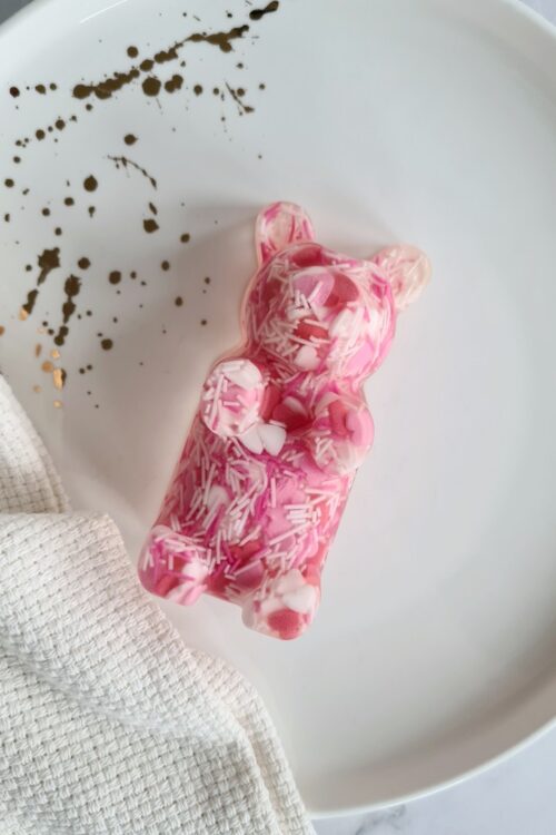 Gummy bear shaped statue, the Charming Teddy, is a handmade art piece from crystal clear resin with pink, red and white sprinkles