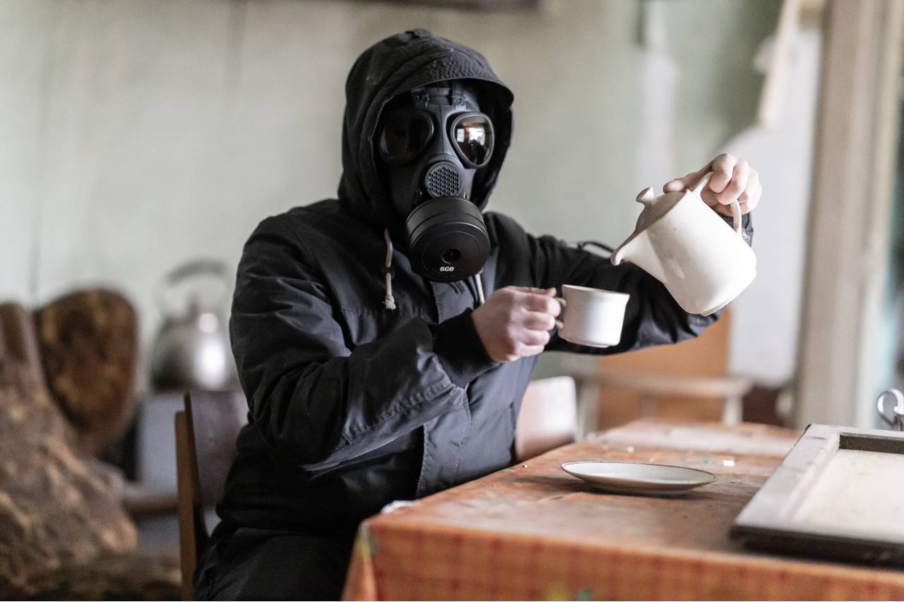Afbeelding van persoon met gasmaker en volledig beschermend pak