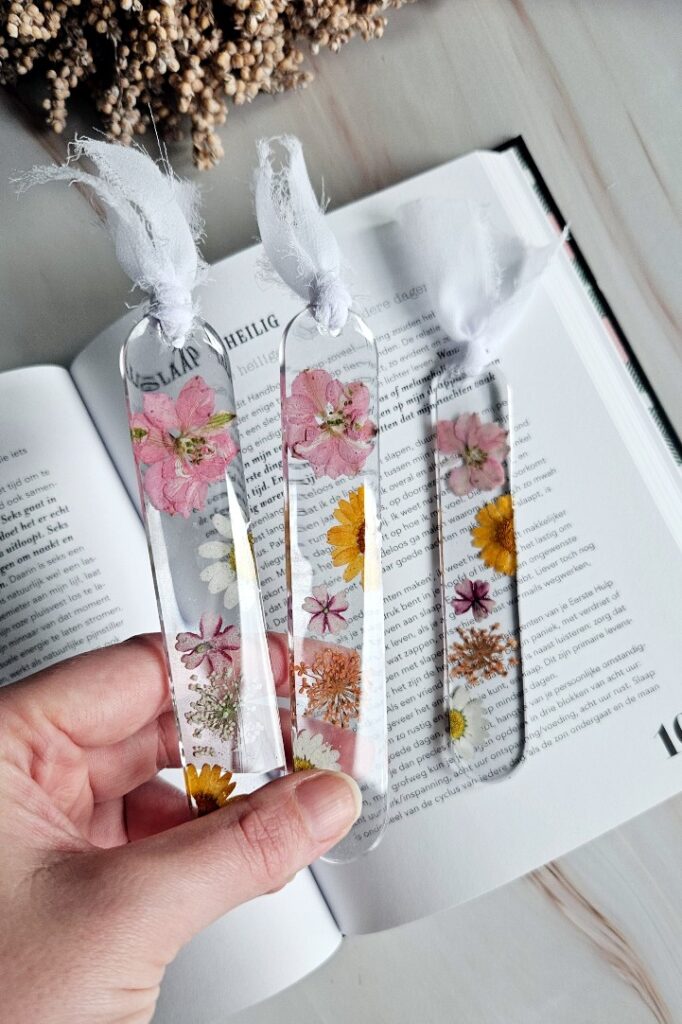 Handmade resin bookmark from transparant epoxy resin with pink, orange and white flower design