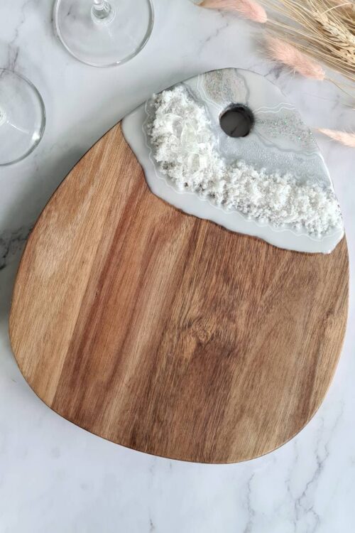 Drop shaped wooden cheese board decorated with silver white resin