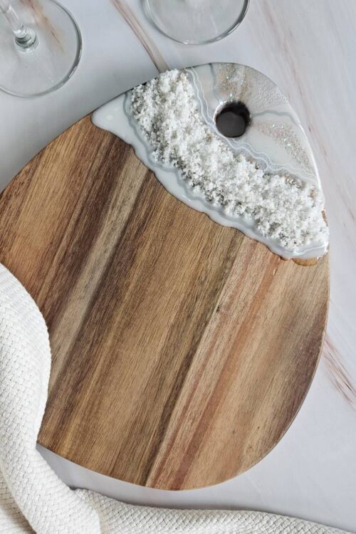 Drop shaped wooden cheese board decorated with silver white resin