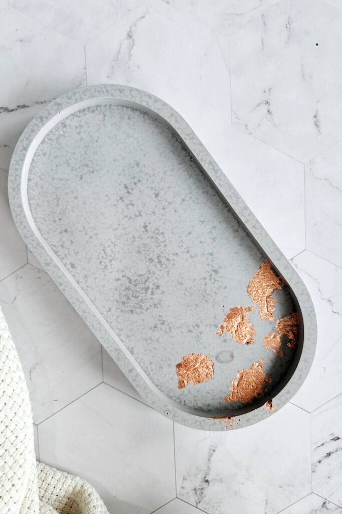 Oval jewerly dish made with gray Jesmonite with copper flakes