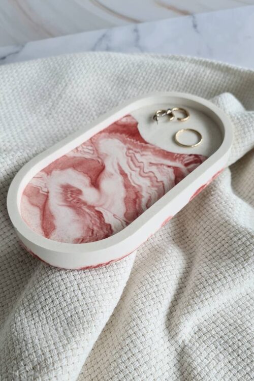 Oval jewerly dish made with white Jesmonite and red swirls