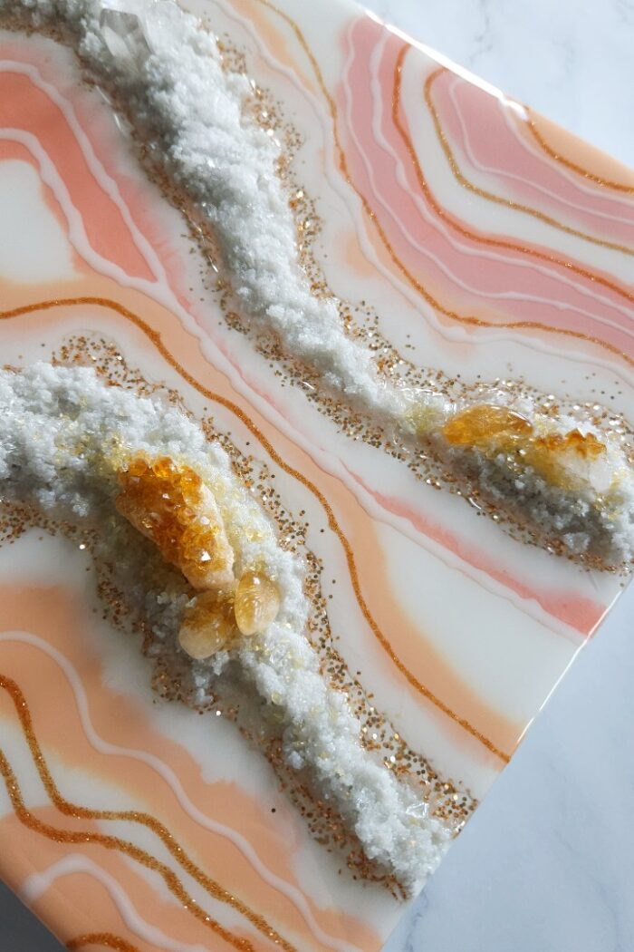 Handmade pink and orange resin wall art with rock crystal and citrine crystal.
